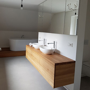 Badezimmer mit zwei Waschbecken und einem Waschtisch aus Holz