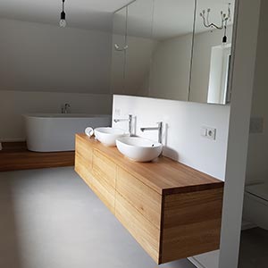 Badezimmer mit zwei Waschbecken und Waschtisch aus Holz